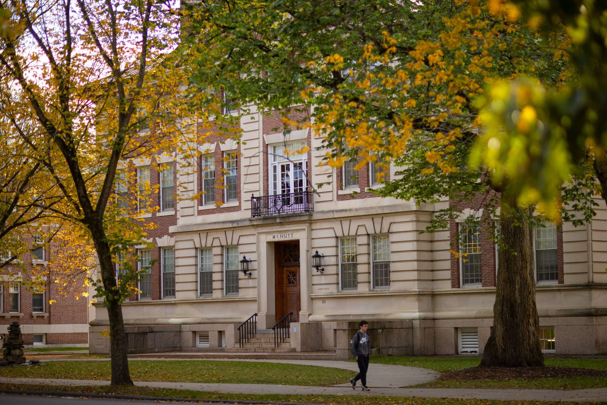 A student walks by McNutt Hall at Dartmouth College.