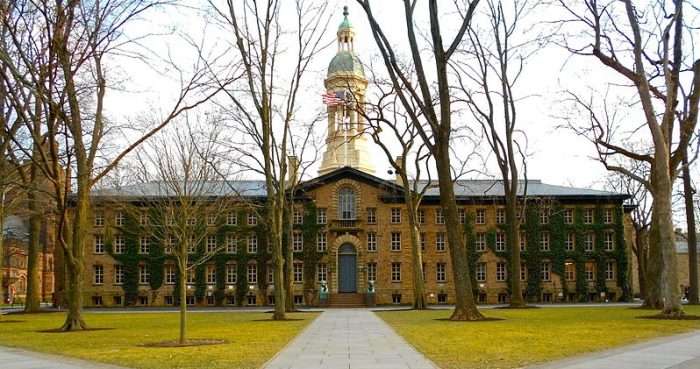 A Princeton University building is featured behind a set of trees.
